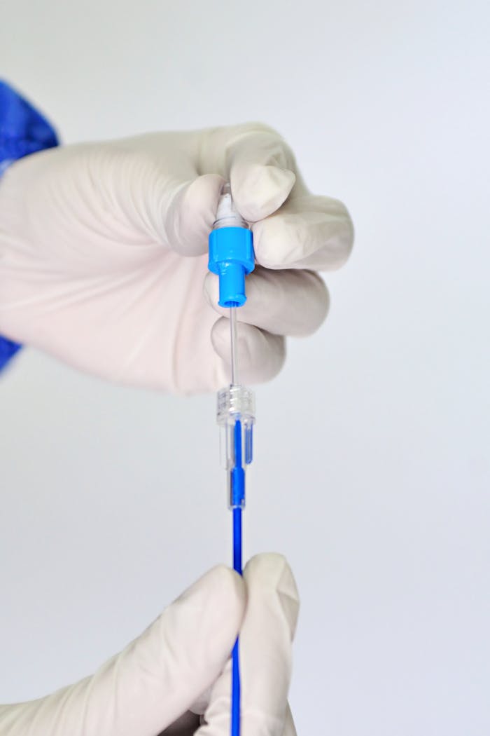 Healthcare professional holding a sterile swab, showcasing precise laboratory handling with gloves.